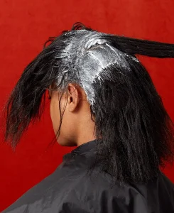 A hair salon client receiving a relaxer treatment.Credit.N
